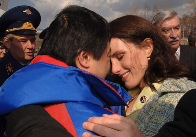 Expedition 10 Commander Leroy Chiao, left, is greeted by his wife after arriving in Star City, Russia from Kazakhstan, Monday, April 25, 2005.  The Expedition 10 crew brought their Soyuz TMA-5 capsule to a pre-dawn landing April 25 northeast of the town of Arkalyk to wrap up a six-month mission aboard the International Space Station for Chiao and Sharipov, and a ten-day mission for Vittori, who flew under a commercial contract between ESA and the Russian Federal Space Agency.  Photo Credit: (NASA/Bill Ingalls)