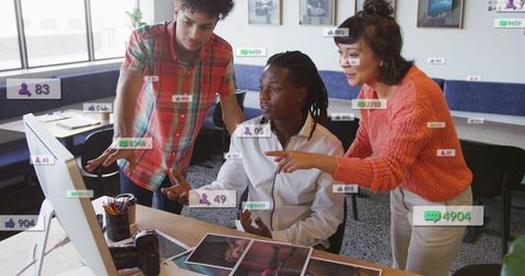 Creative team collaborating at desktop with dslr and prints, reviewing design concepts