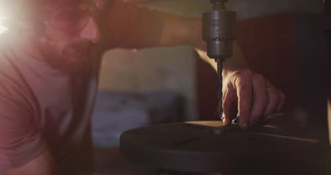 Skilled Blacksmith Drilling Metal in Workshop