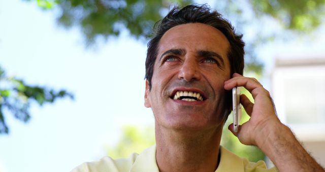 Smiling Man Talking on Mobile Phone Outdoors on Sunny Day - Download Free Stock Images Pikwizard.com