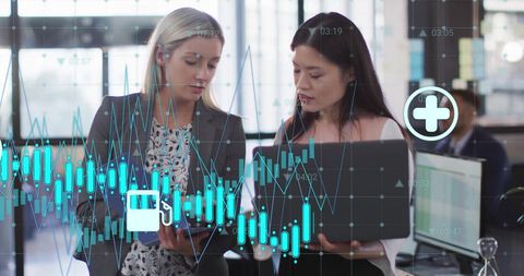 Businesswomen analyzing data with healthcare symbols in modern office
