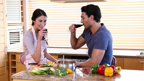 Couple Enjoying Wine Together while Cooking in Kitchen