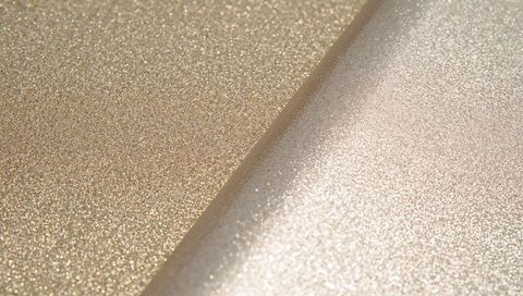 Gleaming gold and champagne glitter sheets meeting at diagonal seam