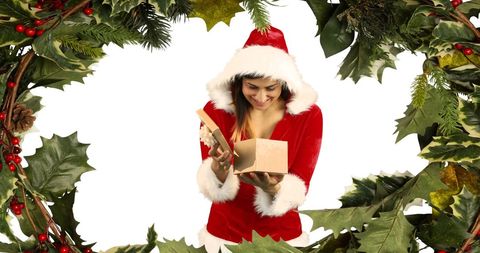 Festive Woman in Santa Costume Happily Opening Christmas Gift