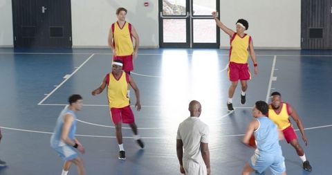 Male Athletes Competing Intensely on Indoor Basketball Court