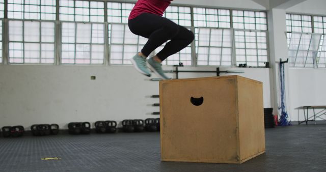 Fit caucasian woman jumping on pylo box at the gym. sports, training and fitness concept