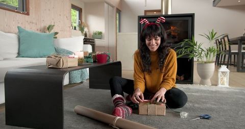 Woman Wrapping Gifts in Cozy Modern Living Room Holiday Scene