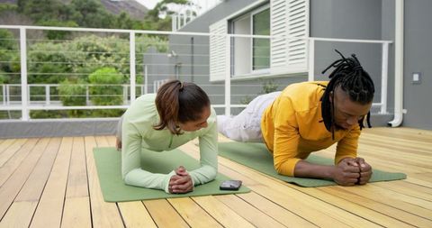 Diverse Couple Doing Plank Exercise on Outdoor Deck Morning Wellness Workout for Fitness Motivation