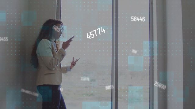 Businesswoman talking on smartphone while standing near a large window in a modern office. Various numeric data overlays hint at the incorporation of technology and data analytics. Useful for depicting professionalism, modern business environments, technology integration, and dynamic corporate settings. Suitable for business presentations, websites, tech articles, and advertisements targeting corporate and entrepreneurial audiences.