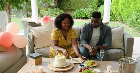 Joyful Moment with Cake and Fruit on Cozy Patio Gathering