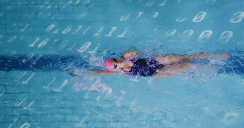 Female swimmer gliding through water with binary code overlay