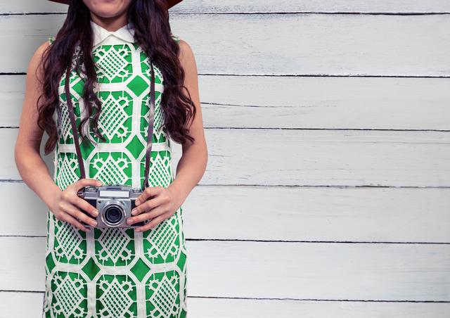 Young Woman in Green Dress Holding Vintage Camera Against White Wooden Wall - Download Free Stock Photos Pikwizard.com