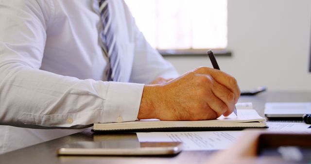 Businessman Writing Notes at Office Desk In Daylight - Download Free Stock Images Pikwizard.com