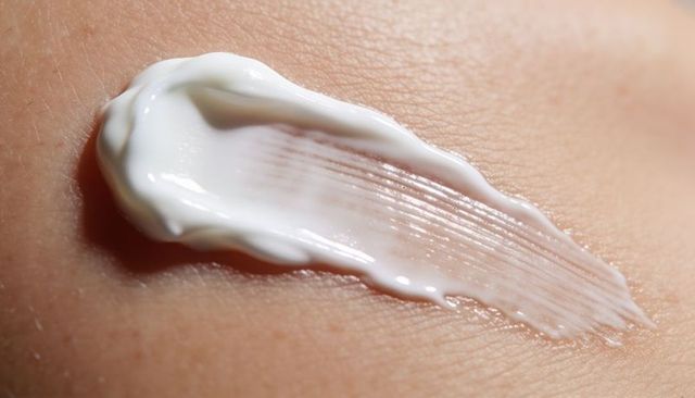 Macro cream smear on skin showing moisturizing texture, pores and application streaks