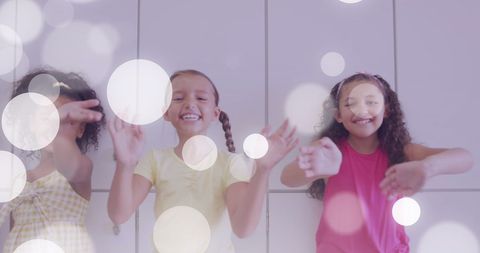 Joyful schoolgirls waving enthusiastically near lockers