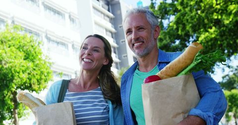 Smiling Mature Couple Enjoying an Outdoor Grocery Walk