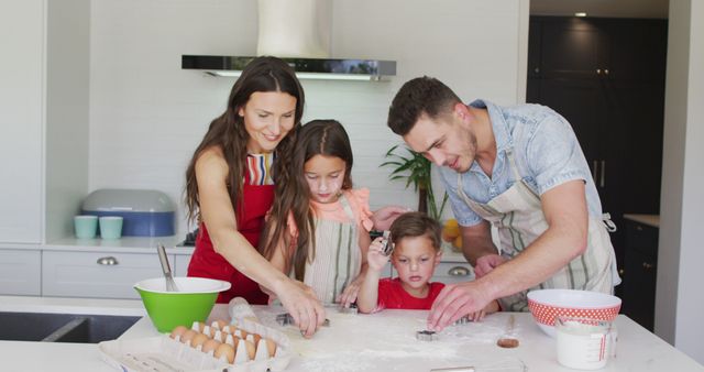 Happy caucasian family baking together, preparing cookies in kitchen. family time, having fun together at home.