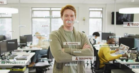 Confident red-haired professional standing in modern open office with data overlays