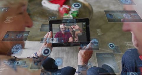 Senior couple video calling on tablet for christmas with holographic ar overlays, cozy