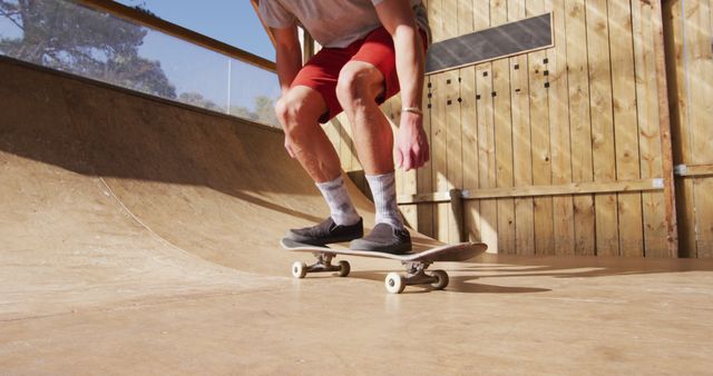 Image of low section of caucasian male skateboarder training in skate park. Skateboarding, sport, active lifestyle and hobby concept.