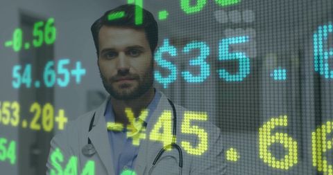 Doctor standing in corridor wearing lab coat and stethoscope with financial ticker overlay
