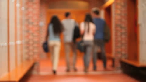 Teen Students Walking in School Hallway Talking
