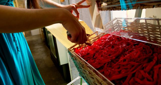 Woman creating ribbon decorations with baskets of colorful material - Download Free Stock Images Pikwizard.com