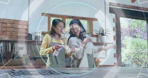 Two Women Cleaning Kitchen Together with Smart HUD Overlay Showing Connected Home Tech