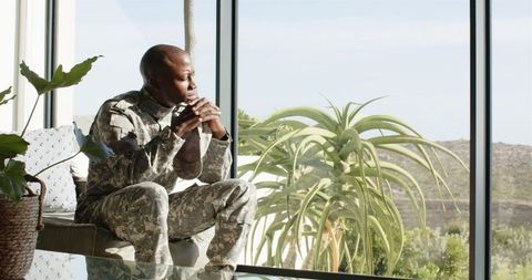 Contemplative Soldier in Military Uniform by Window
