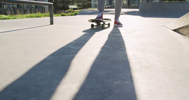 Person in Sneakers with Skateboard Casting Long Shadow on Skate Park - Download Free Stock Images Pikwizard.com