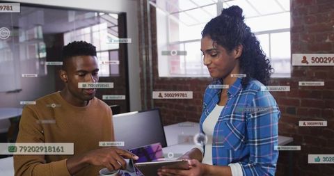 Colleagues collaborating over tablet with augmented reality overlays in modern loft office