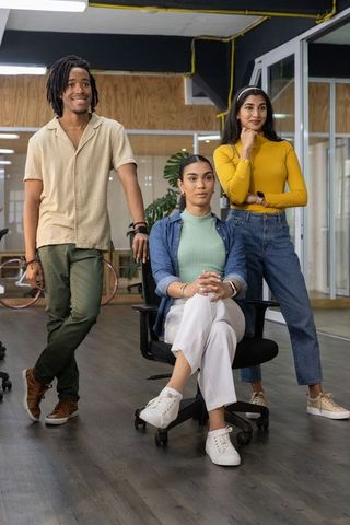 Multicultural team posing in modern open-plan office, collaborating confidently