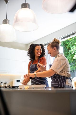 Smiling Friends Cooking Together in Modern Kitchen