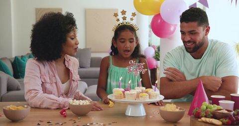 Diverse Family Celebrating Birthday with Cupcakes and Balloons at Home