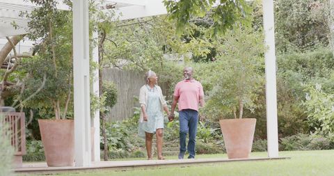 Joyful Senior Couple Strolling in Garden Holding Hands - Download Free Stock Images Pikwizard.com