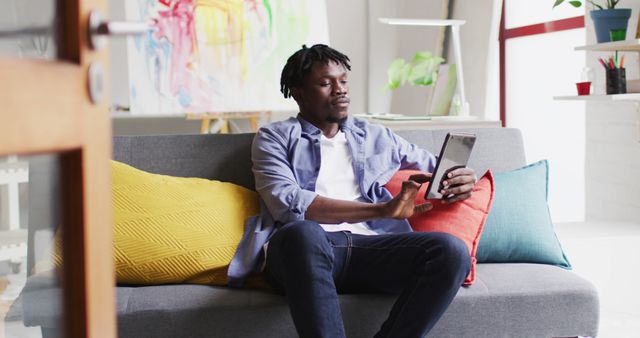 Man Relaxing on Couch Using Tablet in Modern Home - Download Free Stock Images Pikwizard.com