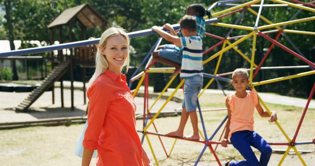 Female Teacher Supervising Children Playing on Playground Climbing Frame - Download Free Stock Images Pikwizard.com