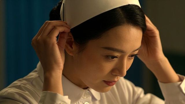 Nurse adjusting cap preparing for shift closeup focused clinical care portrait