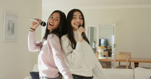 Two friends enjoying karaoke session at home