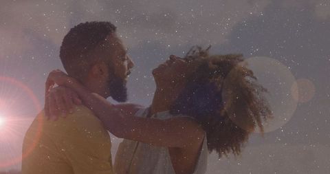 Happy couple embracing under starry sunlit sky