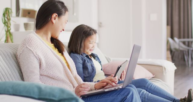 Mother and Daughter Bonding with Laptops and Tablet on Cozy Sofa at Home - Download Free Stock Images Pikwizard.com