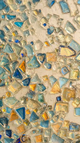 Panning up over iridescent glass mosaic panel, showing shimmering tesserae and warm glow