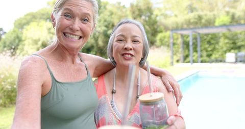 Diverse Mature Friends Enjoying Relaxed Poolside Moment Outdoors