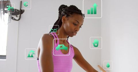 Woman practicing ballet barre with augmented reality fitness and sustainability icons