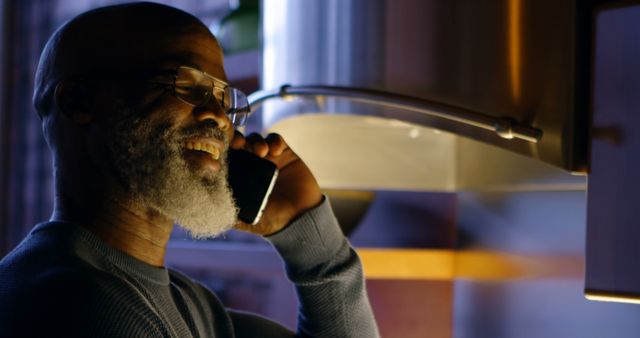 Bearded Senior Man Enjoying a Phone Call in Warm Kitchen Lighting - Download Free Stock Images Pikwizard.com