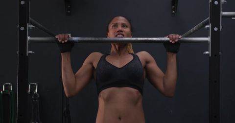 Female athlete performing pull-up exercise for strength and muscle