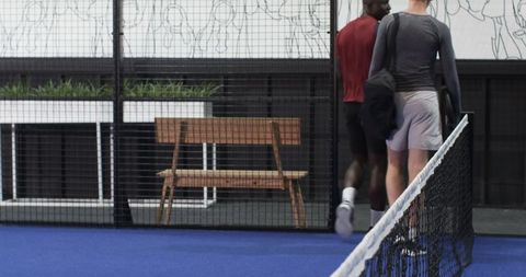 Diverse male friends leaving padel court after match