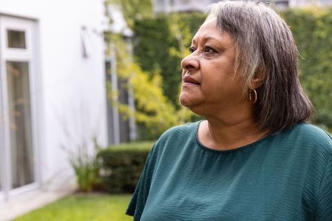 Senior Woman Reflecting in Lush Garden on Joyful Day