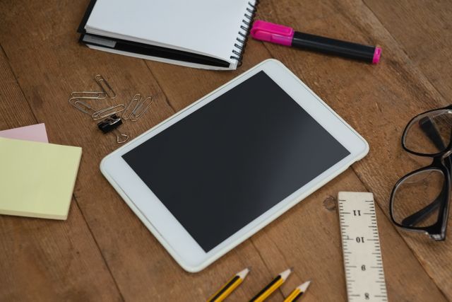 Close-up of school supplies, digital tablet and spectacles on wooden table
