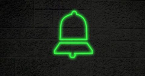 Glowing Green Neon Bell Sign on Textured Brick Wall